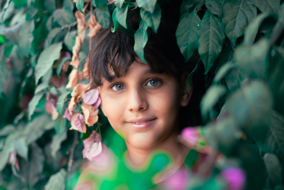 A child looking through leaves representing growth and future security